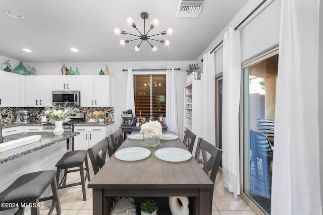 tiled dining space with a chandelier