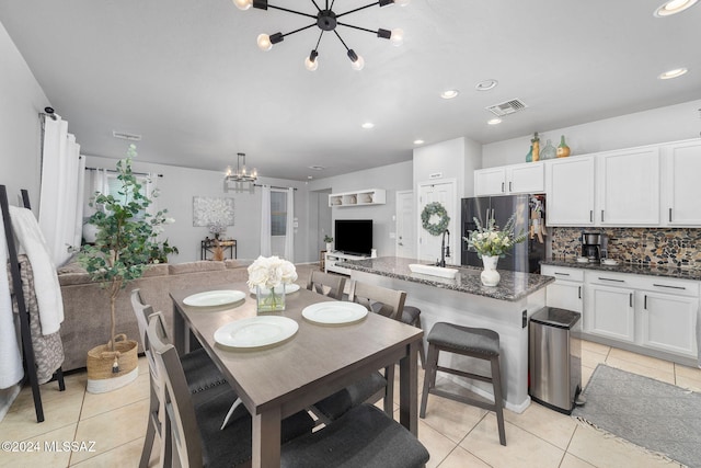 dining space with light tile patterned floors and a chandelier