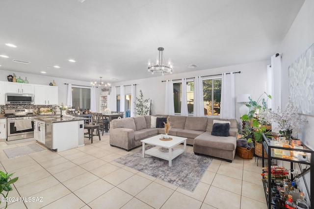 living room featuring sink, light tile patterned floors, and a chandelier