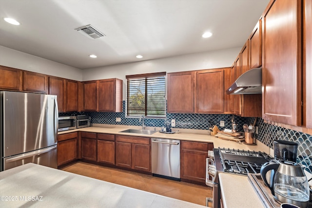 kitchen with appliances with stainless steel finishes, backsplash, sink, exhaust hood, and light tile patterned floors