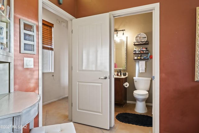 bathroom featuring tile patterned flooring, vanity, and toilet