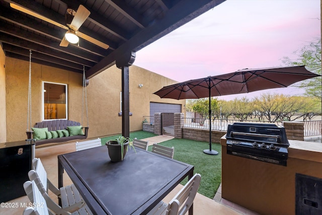 patio terrace at dusk with area for grilling and a lawn