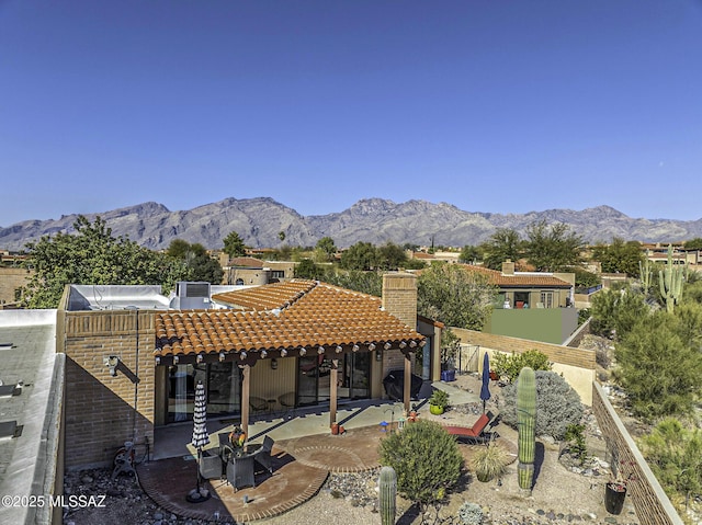 rear view of house with a mountain view and a patio area