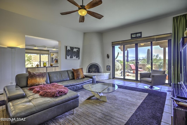 tiled living room with rail lighting, a large fireplace, and ceiling fan