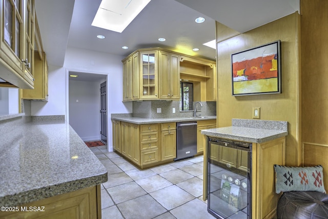 kitchen with wine cooler, light tile patterned flooring, a skylight, black dishwasher, and backsplash