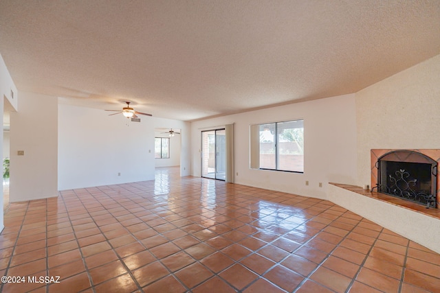 unfurnished living room featuring tile patterned flooring, a textured ceiling, and ceiling fan