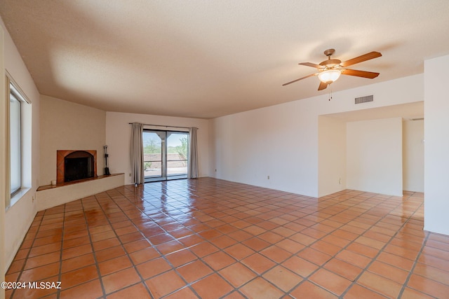 unfurnished living room featuring tile patterned floors and ceiling fan