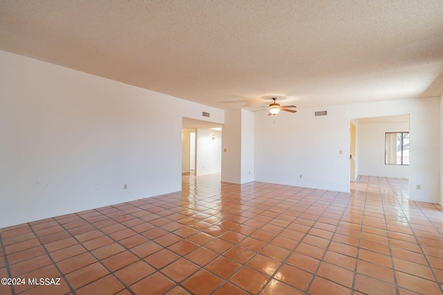 unfurnished room with tile patterned floors, ceiling fan, and a textured ceiling