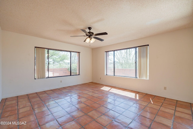 tiled empty room featuring a textured ceiling and ceiling fan