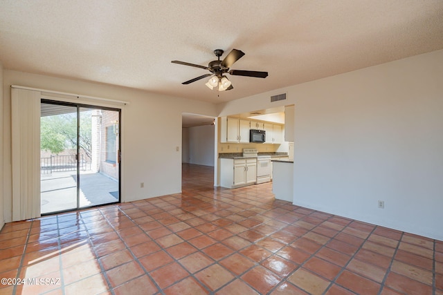 unfurnished living room with tile patterned flooring, ceiling fan, and a textured ceiling