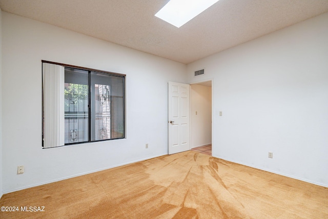 empty room with a skylight and carpet