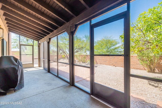 unfurnished sunroom featuring wooden ceiling and lofted ceiling with beams