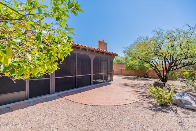 rear view of house featuring a sunroom and a patio