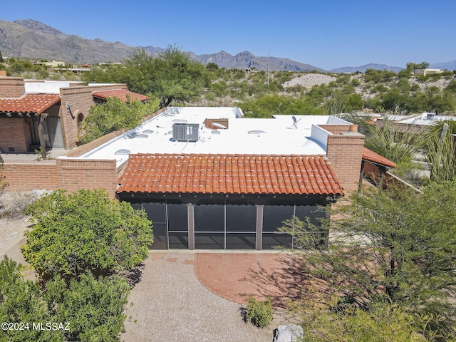 view of front facade with a sunroom and a mountain view