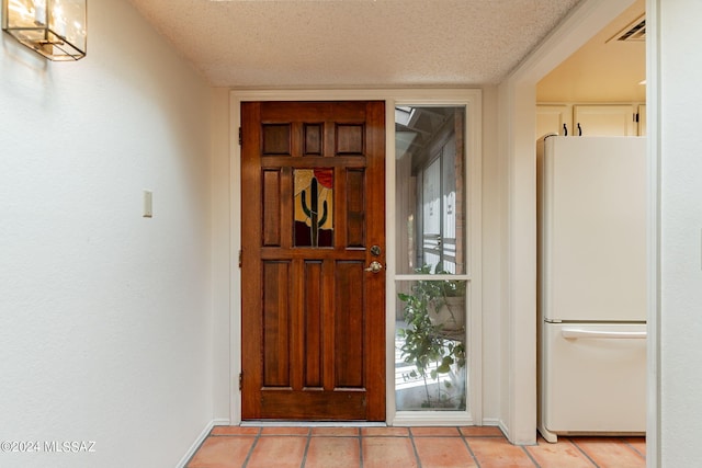 tiled foyer with a textured ceiling