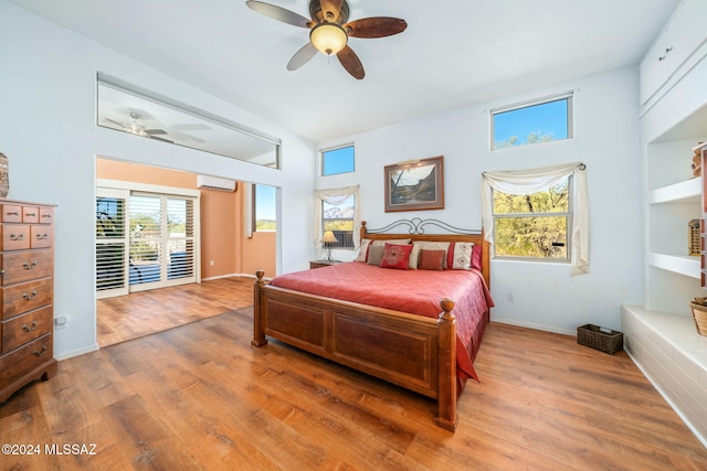 bedroom with hardwood / wood-style floors, ceiling fan, access to exterior, and a wall unit AC