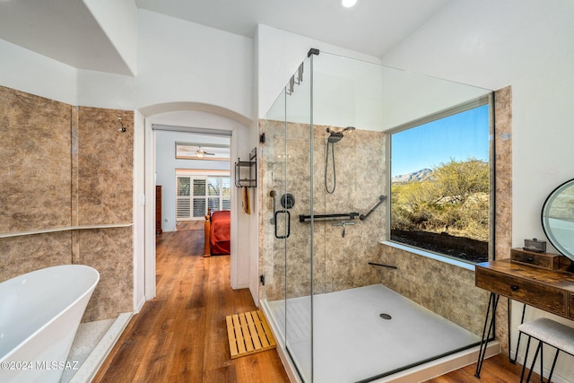 bathroom featuring plus walk in shower, hardwood / wood-style floors, and ceiling fan