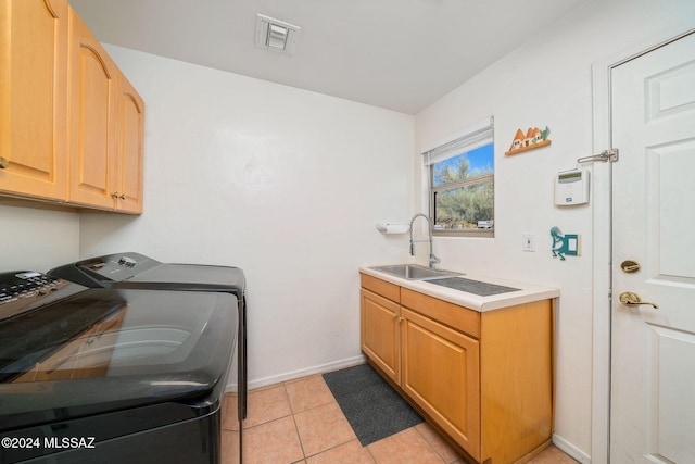 washroom with separate washer and dryer, sink, light tile patterned floors, and cabinets