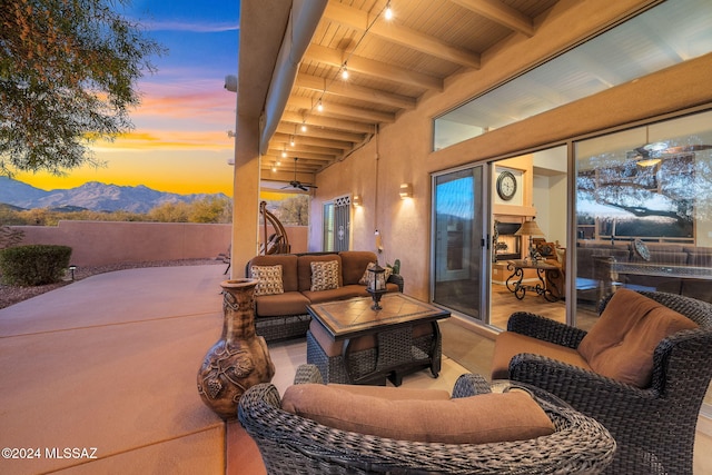 patio terrace at dusk featuring a mountain view and an outdoor living space