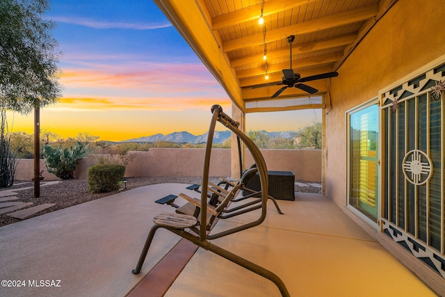 patio terrace at dusk with a mountain view and ceiling fan