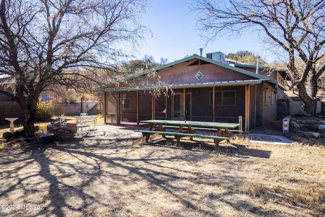 rear view of house featuring a sunroom