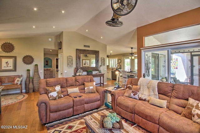 living room with light wood-type flooring, high vaulted ceiling, and ceiling fan