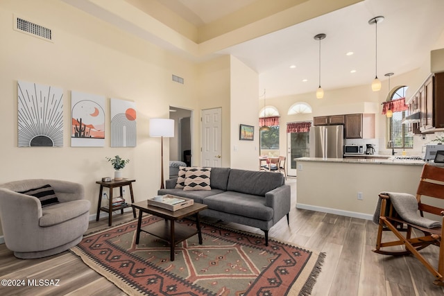 living room featuring light hardwood / wood-style flooring and a high ceiling