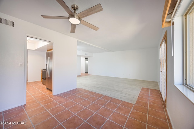 tiled empty room featuring ceiling fan