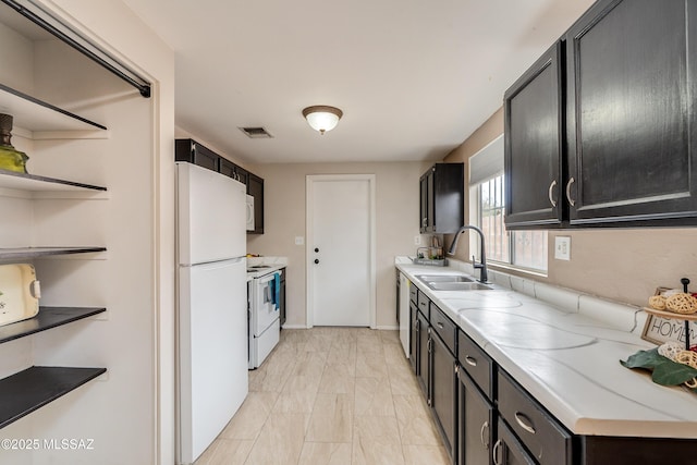 kitchen with sink, light stone counters, and white appliances