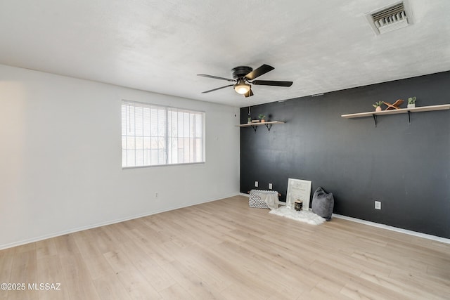 empty room featuring ceiling fan and light hardwood / wood-style flooring