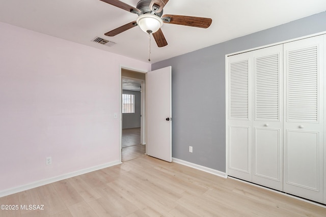 unfurnished bedroom with light hardwood / wood-style floors, ceiling fan, and a closet