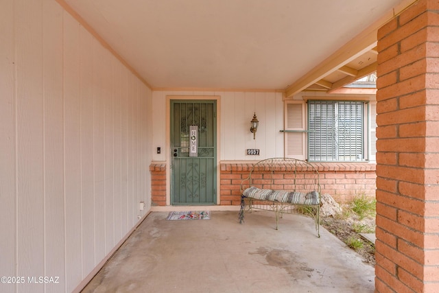 view of exterior entry with a patio