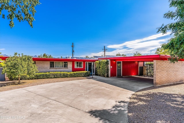 ranch-style home featuring a carport and concrete driveway