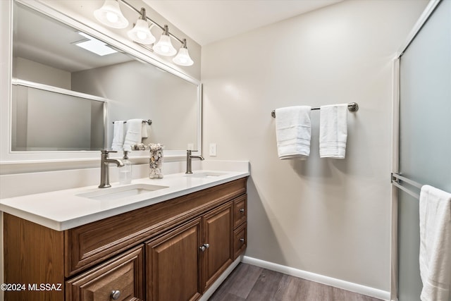 bathroom with hardwood / wood-style floors, vanity, and an enclosed shower