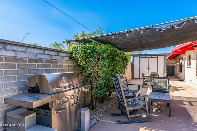 view of patio / terrace with a shed and a grill