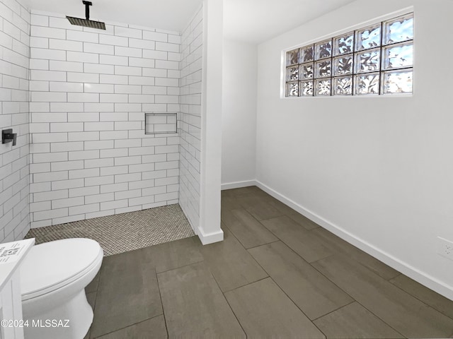 bathroom with tiled shower, tile patterned flooring, and toilet