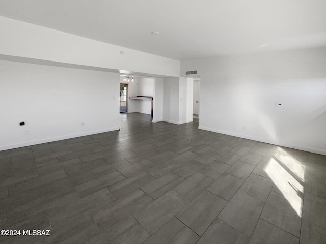 unfurnished living room with a notable chandelier