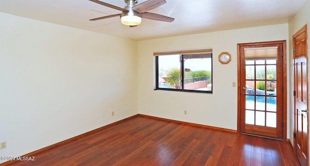 empty room with ceiling fan and dark hardwood / wood-style flooring