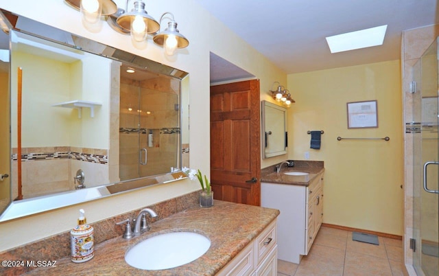 bathroom with an enclosed shower, vanity, a skylight, and tile patterned floors