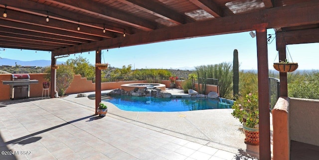 view of swimming pool with an in ground hot tub, area for grilling, and a patio area