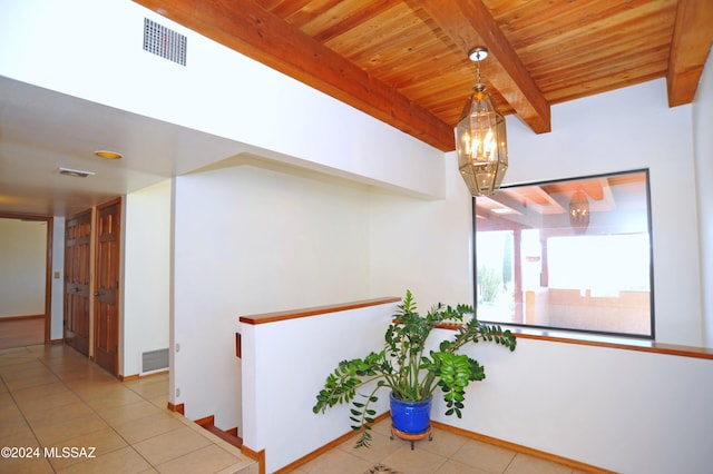 hall with a notable chandelier, wood ceiling, beamed ceiling, and light tile patterned flooring