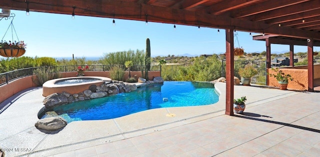 view of pool featuring an in ground hot tub, pool water feature, and a patio