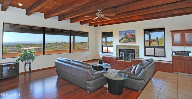 living room featuring dark hardwood / wood-style flooring, a fireplace, wooden ceiling, and beamed ceiling