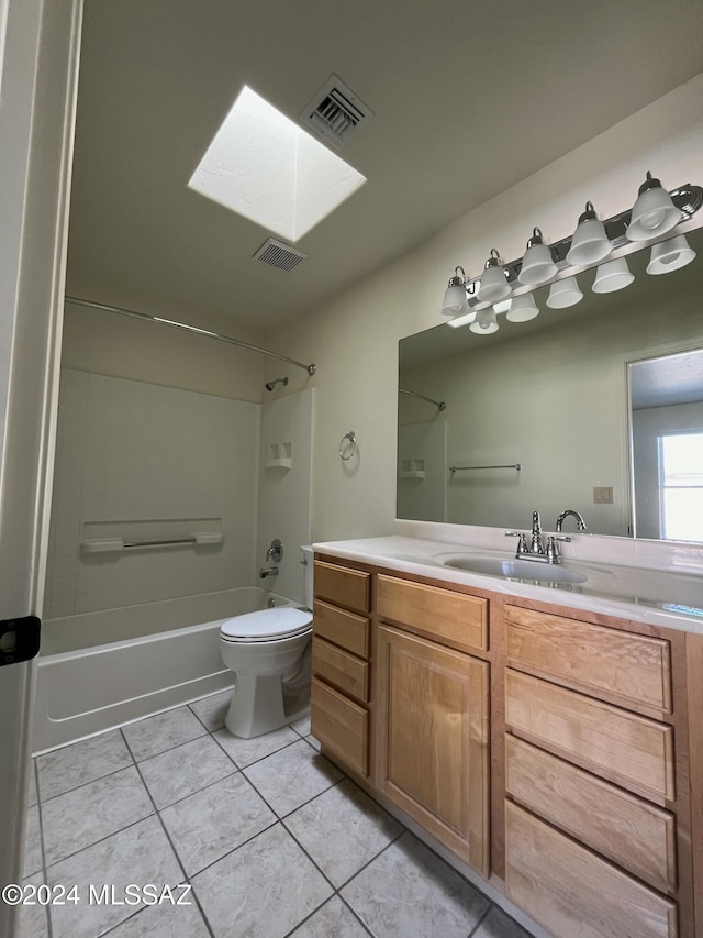 full bathroom with a skylight, vanity, shower / washtub combination, tile patterned flooring, and toilet