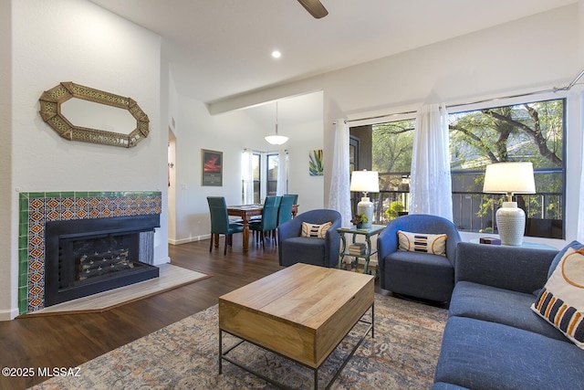 living room with a fireplace, dark hardwood / wood-style floors, and ceiling fan