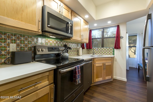 kitchen featuring stainless steel appliances, tasteful backsplash, dark wood-type flooring, and sink