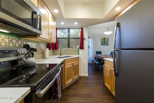 kitchen featuring sink, dark hardwood / wood-style flooring, backsplash, pendant lighting, and appliances with stainless steel finishes