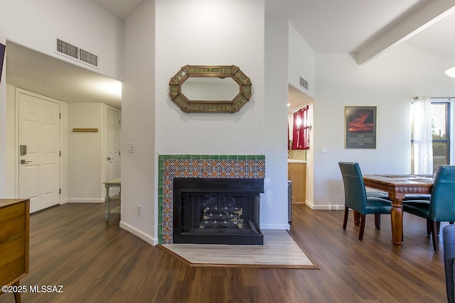 interior space featuring dark wood-type flooring and a tiled fireplace