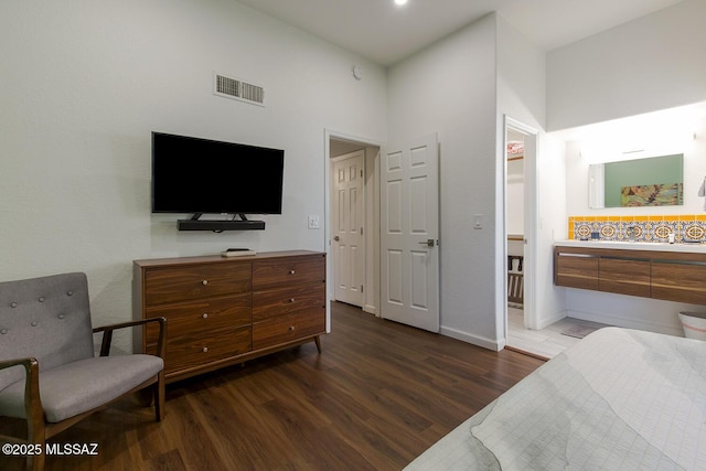 bedroom with a high ceiling and dark hardwood / wood-style floors