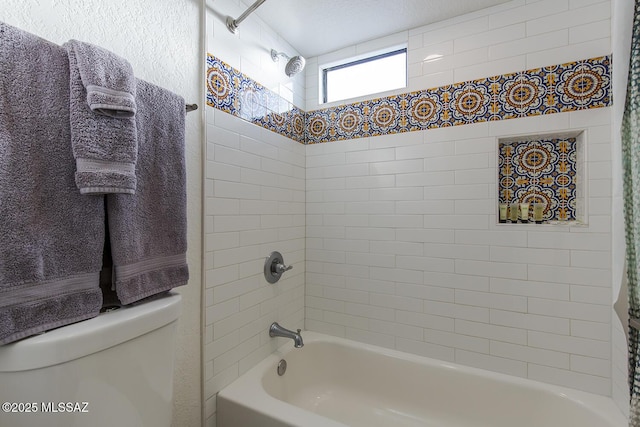 bathroom featuring toilet and tiled shower / bath